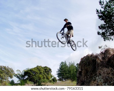 Boy on a bmx bike mid jump high in the air