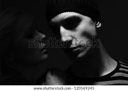 handsome man with hat whispers to him a young woman