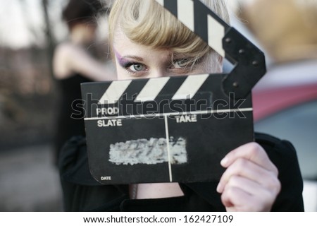 image of a the girl in the film production with clapperboard, young woman holding clapperboard
