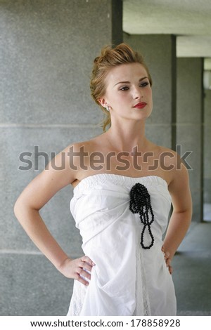woman in a white dress with a black pearl necklace