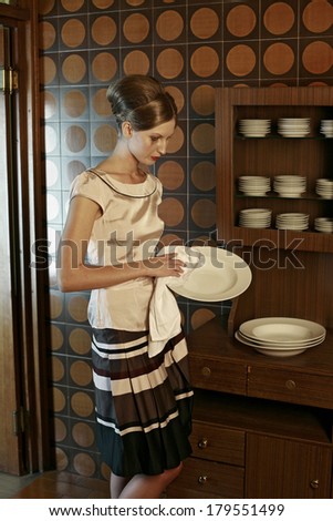 girl washes dishes in a vintage apartment