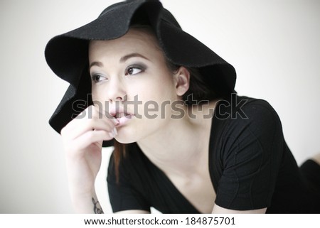 young woman with hat lying on the bed , Beautiful sexy woman in black lingerie with hat posing