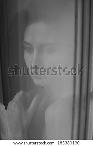 reflection of a beautiful girl in the window , beautiful brunette girl reflected in the window in the room