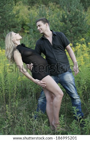 Pregnant Dancer inclined in dance, dance couple dancing tango in nature