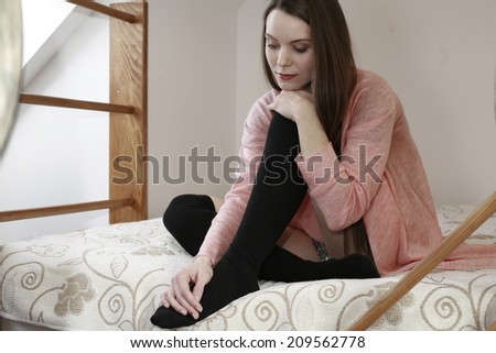 girl on the bed happy dreamy beauty girl hugging her legs while siting in bed against the wooden wall , picture of a girl on the bed happy talking on phone dreamy beauty girl hugging her legs