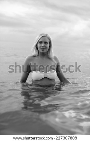 Blond angel in water black and white , blonde girl on the beach, beautiful blonde in water , Blond scandinavian woman by the ocean.Image of a beautiful Blond scandinavian woman by the sea horizon,
