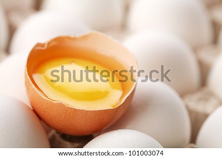 Chicken eggs. One egg is broken.