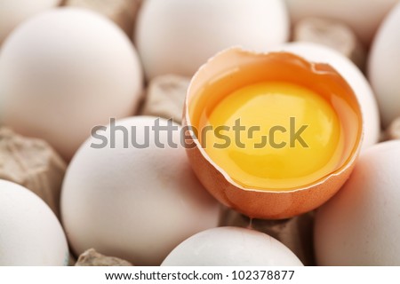 Chicken eggs. One egg is broken.