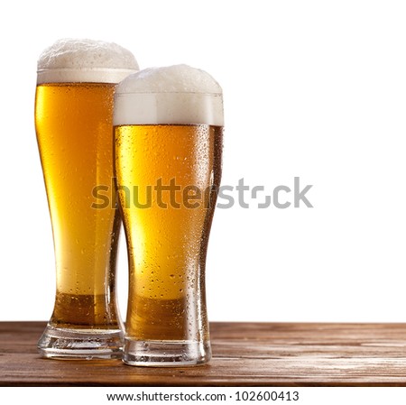 Two Glasses Of Beers On A Wooden Table. Isolated On A White Background.
