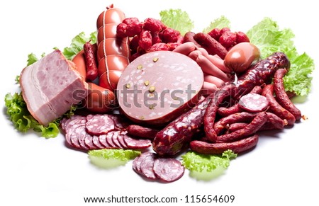 Meat and sausages on lettuce leaves. Isolated on white.