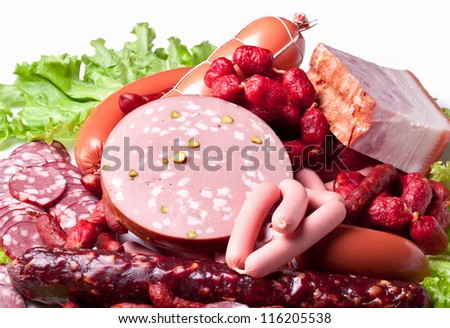 Meat and sausages on lettuce leaves. Isolated on white background from above.