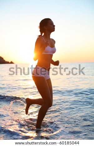 Sexy brunette is running on the beach