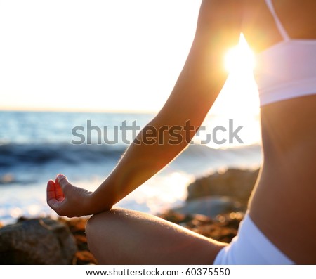 body of a beautiful girl in a meditation on the beach