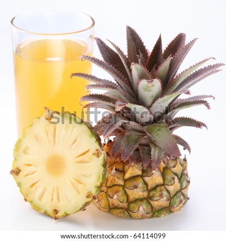 Full glass of fresh pineapple juice and cut pineapple fruit near.