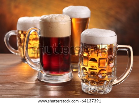 Cool beer mugs over wooden table.