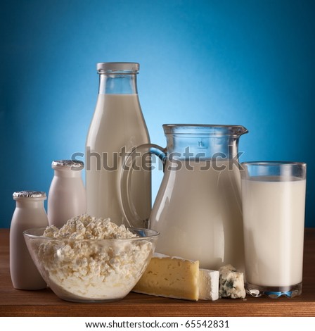 Different milk products: cheese; cream; milk. On a blue background.