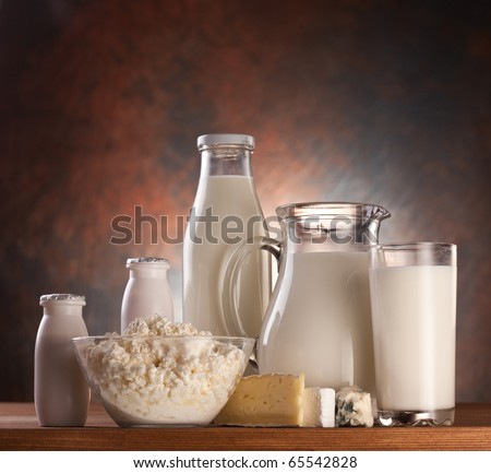 Different milk products: cheese, cream, milk, yohurt. On a brown background.