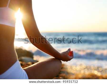 body of a beautiful girl in a meditation on the beach
