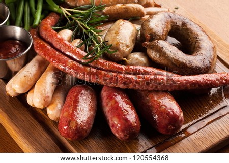Assortment of grilled sausages on a wooden board.