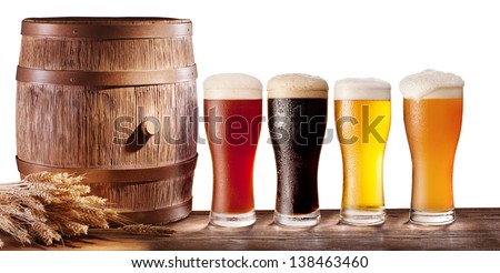 Assortment of beer glasses with a wooden barrel on a white background.