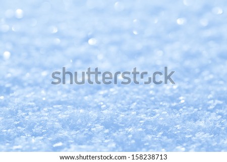 Blue sparkling snow background with white little snowflakes Blue sparkling snow background with white little snowflakes