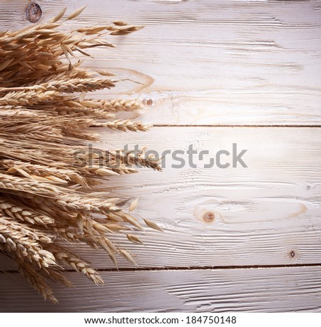 Ears of wheat on old wooden table.