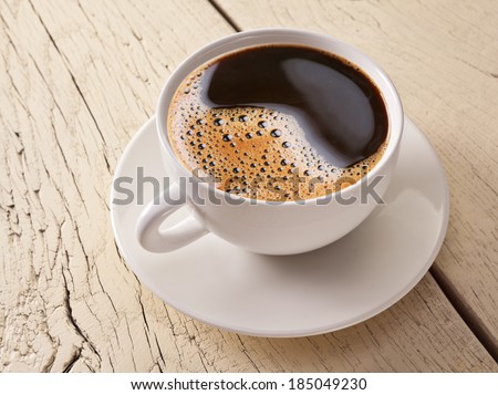 Cup of coffee on old white wooden table.