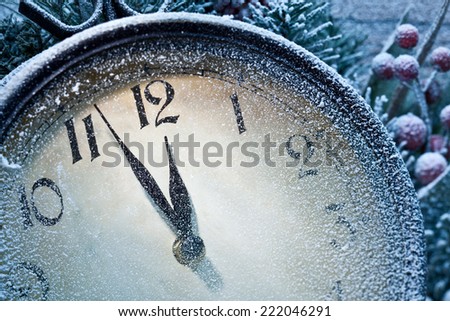 Christmas clock over snow wooden background. Five to twelve.