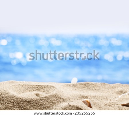 Sand with blurred sea background. File has clipping path for holes in the sand. You can insert the bottle or glass.