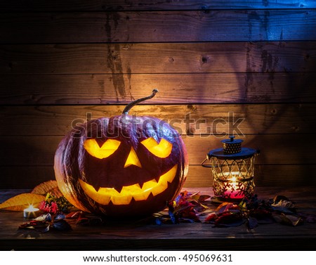 Grinning pumpkin lantern or jack-o\'-lantern is one of the symbols of Halloween. Halloween attribute. Wooden background.