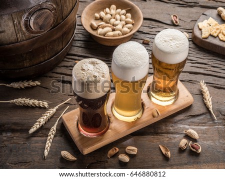 Glasses of beer and snacks on the wooden table. Top view.