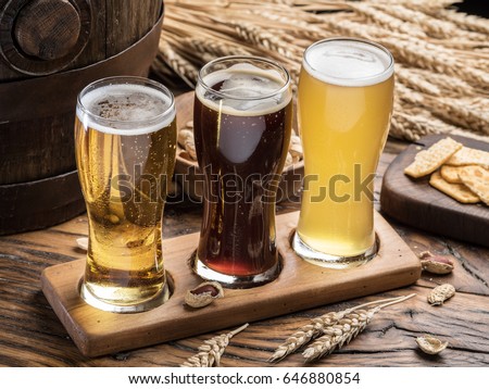 Glasses of beer and snacks on the wooden table. Top view.