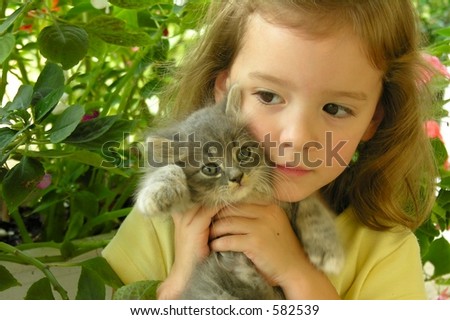 Little girl hugging kitten