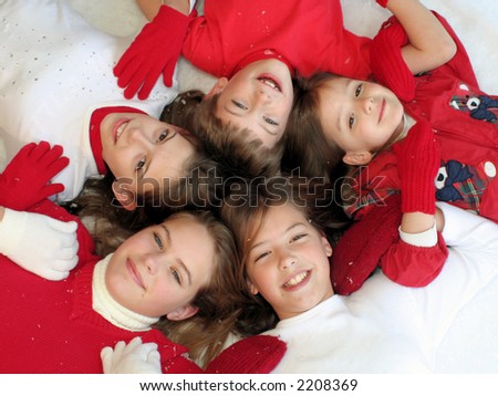 Children in circle wearing red and white in winter setting - linked arms
