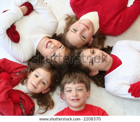Children in circle wearing red and white in winter setting - folded arms