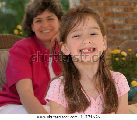 little girl with missing teeth and smiling mother