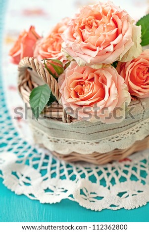 Beautiful  roses in a basket  on a table.
