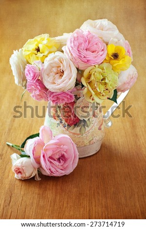 Floral composition with a roses in a vintage jug on a table. vintage style ,grunge paper background.