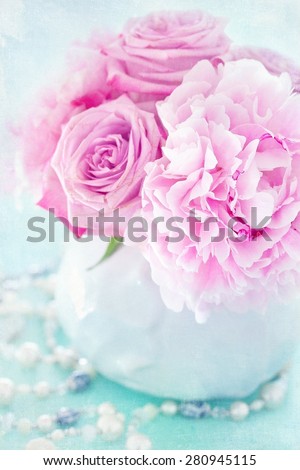 Floral composition with a pink peony and roses in a vase.