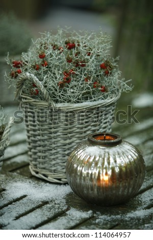 Christmas decorations: plant in wicker basket and a candle