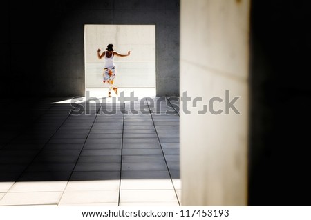 Dramatically lit photograph of woman dancing in a courtyard
