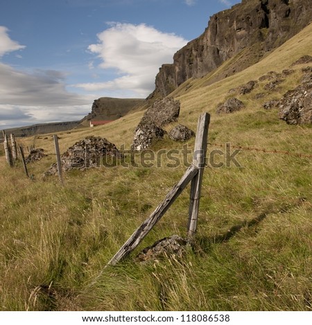 Rural farmland pasture on mountainside with wire fence post