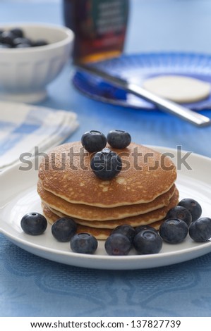 Close-up view of a stack of Pancakes with blueberries. Butter, syrup and berries on the background.