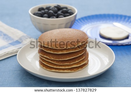 Close-up view of a stack of Pancakes. Butter and berries on the background.