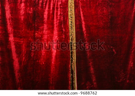 Red velvet curtain with gold fringe.