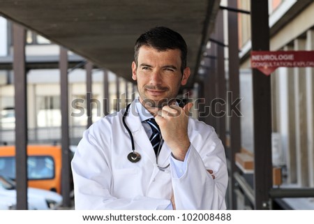 handsome doctor with stethoscope in hospital hall
