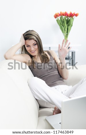 woman on sofa with computer and flowers