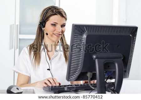 young secretary with headset and computer in office
