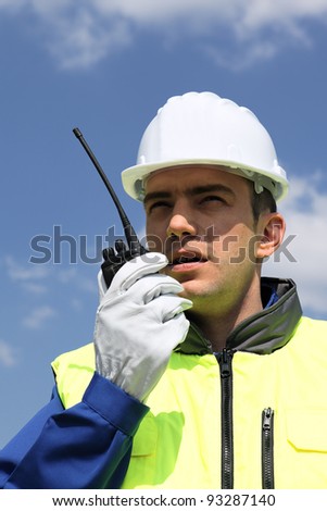 portrait of builder talking in  transmitter on building site
