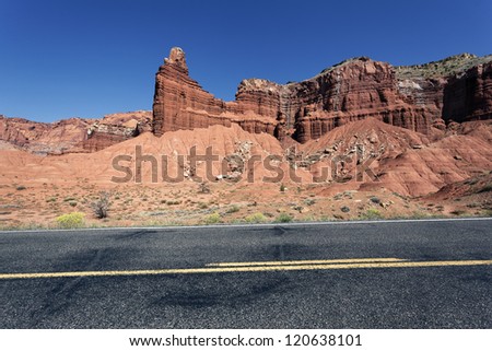 A highway rolling through red rock canyons